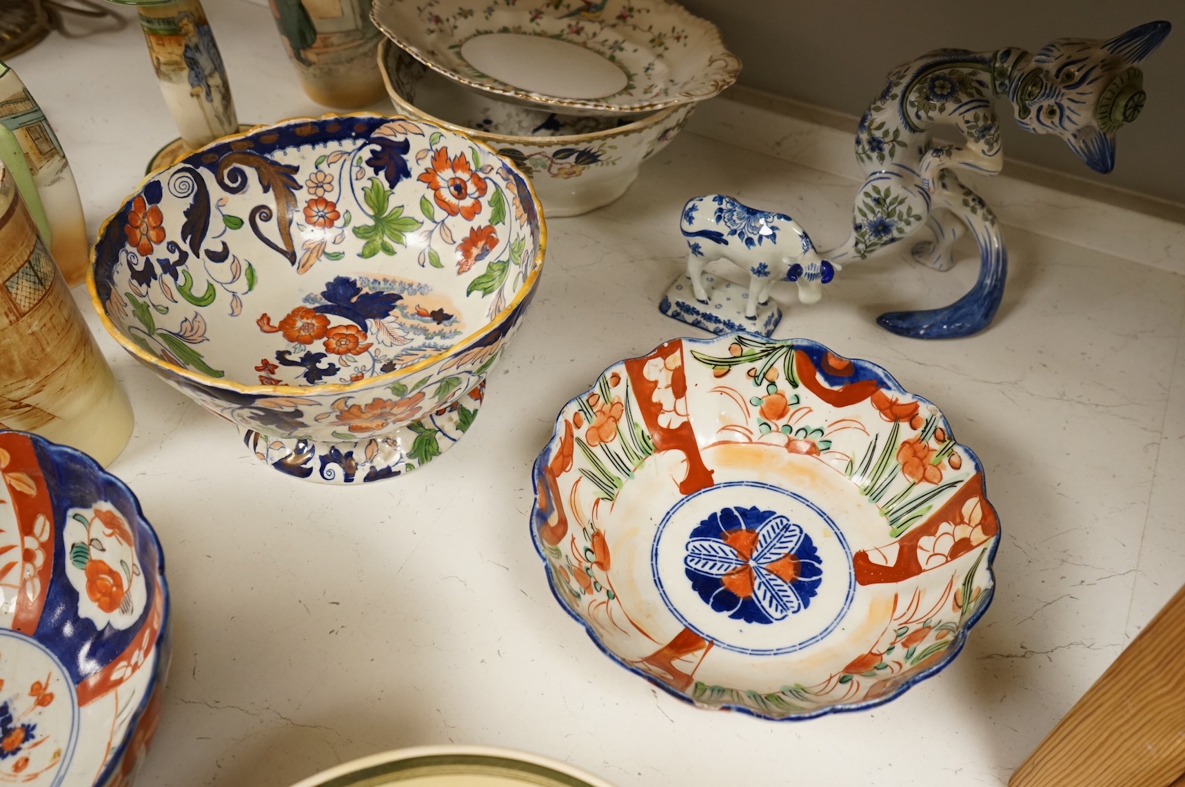 A collection of French, Japanese and English ceramics to include Royal Doulton Dickensware, Imari bowls and a faience glazed cat